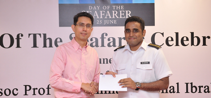 A cadet from the Certificate of Competency course receiving a book prize from Associate Professor Muhammad Faishal